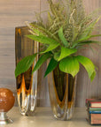 A contemporary Gardeco plant displayed in a Gardeco Glass Vase Triangle 3 Fume Amber with sleek triangular design.