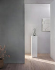Luxury Gardeco To Return sculpture displayed on a white pedestal in a minimal grey living room, a modern art piece available at Spacio India.