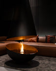Modern living room with a fire pit table and brown sectional sofa.