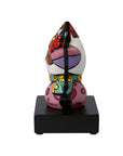 Colorful ceramic sculpture on a black base against a white background
