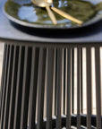 Close-up of a black high table with a blurred plate in the background