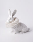 A Haoshi Rabbit Squat Table Lamp with a crown on its head, emitting warm LED light.