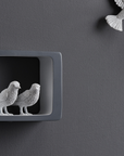 Closer look of Haoshi Sparrow Clock in Dark Gray color on a dark grey wall with small grey boxes available at Spacio india for modern and luxury interiors from our Timepieces and clocks collection.