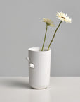 A Haoshi Sparrow Vase L with a flower in it.