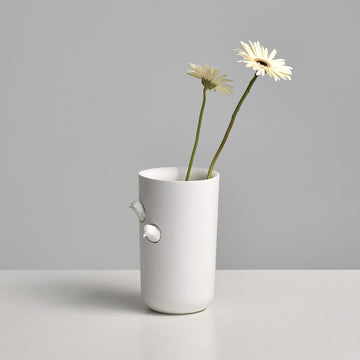 A Haoshi Sparrow Vase L with a flower in it.