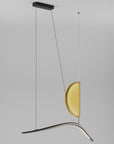 Modern pendant light with a yellow glass shade on a gray background