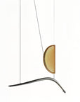 Close-up view of Italamp Borealis Suspension chandelier, crafted in Italy, featuring a curved metal frame and artistic amber glass, offered exclusively by Spacio India.