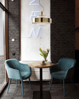 Elegant Italamp Crono Suspension Lamp with layered gold rings and glass pendants, styled in a contemporary café setting, available at Spacio India.