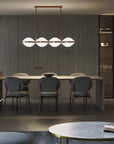 Italamp Ellepi chandelier in bronze metal with satin glass diffusers, suspended over a dining table – available at Spacio India for modern interiors.