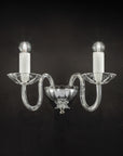 Italamp Evoque Wall Lamp in hand-carved clear crystal with twin arms and candle-style bulbs, available at Spacio India for luxury wall lighting.