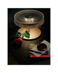 Italamp Gilda table lamp on black side table with rose and books, luxury crystal lighting available at Spacio India for living room or bedroom styling.
