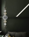 Italamp Greta Suspension Lamp with a polished nickel frame and hand-cut crystal diffuser, styled against a deep green wall – available at Spacio India.