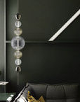 Italamp Greta Suspension Lamp with a polished nickel frame and hand-cut crystal diffuser, styled against a deep green wall – available at Spacio India.