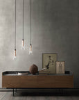 Italamp Licio pendant lamps in clear glass with copper accents, displayed in a modern living room setup. Available at Spacio India.