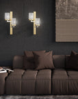Brown sofa with decorative pillows in a room with dark textured walls and wall lights.