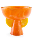 A JA Mustique Pedestal Bowl Orange Yellow by Jonathan Adler on a white surface.
