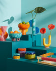 Jonathan Adler Mustique Orange & Yellow Bowl on Blue pedestals with other collection of bowls & vases available in India for Luxury Home Decor accessories collection of Tableware.