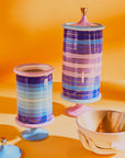 Jonathan Adler Scala stripe Vanister Tall Vase on a orange surface with bowl available at Spacio India for Luxury Home Decor Accessories collection.