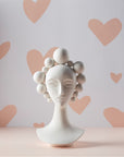 Jonathan Adler Camille Bust Sculpture against a pastel heart-patterned backdrop, perfect decorative porcelain piece available at Spacio India online and retail stores.