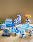 Jonathan Adler Druggist Eye Vase with surrealist apothecary collection on a tan tabletop - high-fired porcelain with gold detailing at Spacio India.