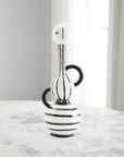 Jonathan Adler Medium Vienna Decanter in porcelain featuring black and white stripes with gold accents, elegantly placed on a marble table. Available at Spacio India retail stores and online.