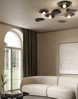 A living room with a white couch, large windows, and a KDLN blown glass lamp.