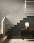 A KDLN Hive table lamp illuminates the staircase in a living room.