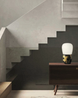 A KDLN Hive table lamp illuminates the staircase in a living room.