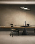 Modern dining area with a black table and chairs against a textured wall.