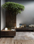 Modern living room with a tree, bench, and decorative items.