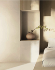 A bed in a bedroom with De Stijl-inspired geometric shapes and a KDLN Model T Floor Lamp.
