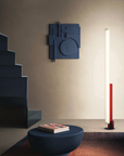 A living room inspired by the De Stijl artistic movement, adorned with geometric shapes and featuring a KDLN Model T Floor Lamp and a table.