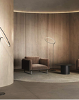 A modern living room with flexible wooden furniture configurations and a KDLN Poise Floor Lamp serving as a light source.
