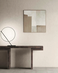 A KDLN Poise Table Lamp emits a circle of light, illuminating a painting on the wall.