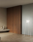 Modern interior with wooden wall paneling, floor lamp, and minimal decor.