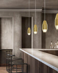 Modern interior with 3 brushed pendant lights and a bar counter.