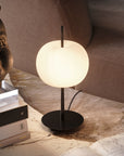 Table lamp on a marble surface with books and a decorative item.
