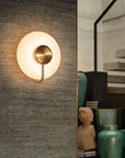 KDLN Tratto Wall in brass finish on a fabric panelled wall near a staircase in a modern home