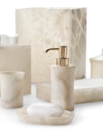 Beige marble bathroom accessories from Labrazel including a soap dispenser, soap dish, and containers on a white background.