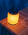 Yellow textured solar lantern on a tiled surface with a dark blue background