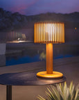 Indoor Outdoor solar lamp on a table by a pool at night by Les Jardins available at Spacio retail stores in Mumbai & Kolkata.