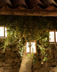 Decorative solar lanterns hanging from a stone wall with a rustic roof by Les Jardins available at Spacio retail stores in Mumbai & Kolkata.