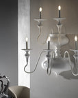 White wall-mounted candle holder with four lit candles against a neutral background from Lorenzon available at Spacio in India.