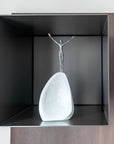 Abstract sculpture of a figure on a rock in a black box