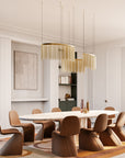 Text: Luxurious dining room featuring the Lustralis modular chandelier by Masiero, available at Spacio in India - elegant golden chains and soft lighting for refined interiors.
