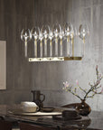 Modern dining room with a chandelier, table setting, and decorative elements.