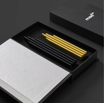 A ML Skyline Collection Black & Gold (2pc set) box with a yellow pen by Madlab.