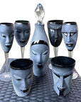 Maleras Crystal Champagne Glass Electra Black with other drink ware accessories and Electra decanter from Masque collection on a woven table ground for modern interiors available at Spacio India from Bar Accessories Collection.