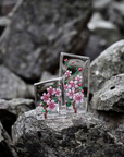 Distant look of Maleras Crystal Sculpture Cherry Blossom Large with other Small sculpture on a Grey stones outdoor back ground available at Spacio India from the Sculptures and Art Objects Collection.
