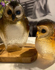 Maleras Small Crystal Brown Owl Swedish Glass Art, artistically presented alongside a larger crystal owl sculpture, showcasing intricate detailing and rich hues, available at Spacio India retail stores and online.